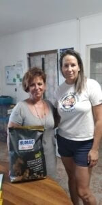 Bara Ildi, a HUMAC Natur AFM® alapítója egy menhelyi dolgozóval és a HUMAC termékkel, amelyet a menhelyi kutyák támogatására ajánlanak.